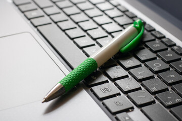 Laptop keyboard black on gray background with a pen on it. Close-up of laptop keyboard.
