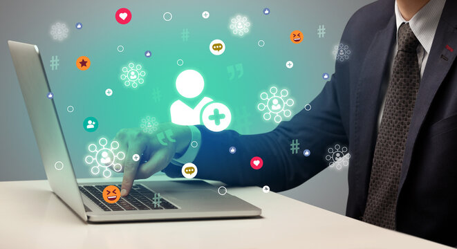 Hand surfing on the social media with friend request icons coming out from the screen, networking concept