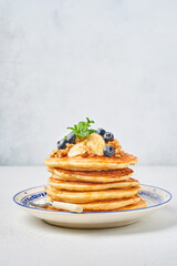 Pancakes with banana, walnut, honey and caramel for a breakfast. Selective focus.