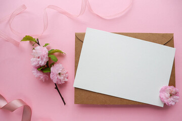 invitation card with sakura blossom branch on pink background 
