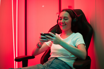 Young female teenage cyber sport gamer play mobile game by smartphone on eSport tournament