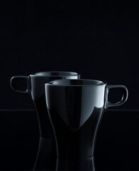 Two ceramic mugs on a dark background