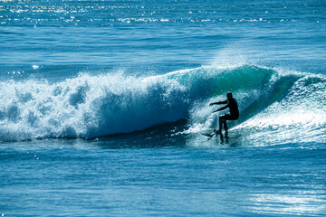 Silhouettes of Surfer riding a Waves in the Mediterranean Sea. Selective focus background