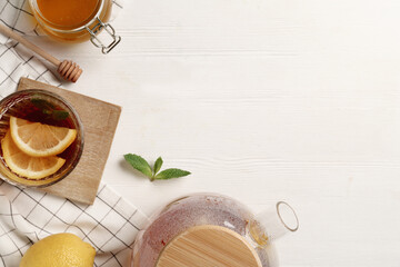 Flat lay composition with hot tea on white wooden table. Space for text