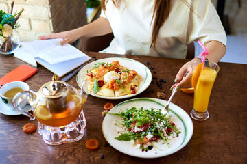 the girl at the table eats restaurant dishes