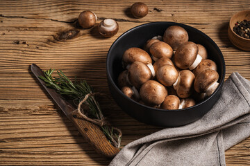 Bowl of mushrooms and bunch of fresh rosemary, top view