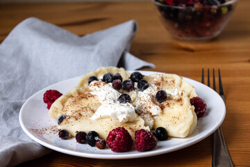 Homemade dumplings with cottage cheese made by hand with sour cream and fresh berries.