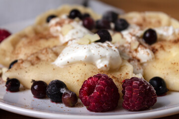 Homemade dumplings with cottage cheese made by hand with sour cream and fresh berries.