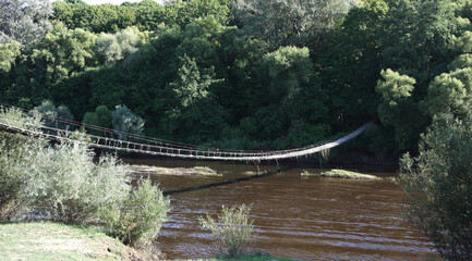 Hanging old wooden bridge over the river.