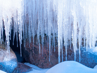 In the winter, stones are icy on the sea shore. Icicles hung from large pieces of ice