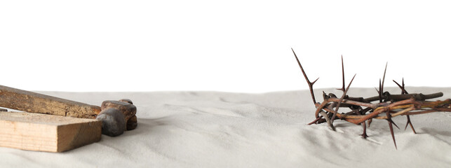 Crown of thorns, wooden plank and hammer on sand against white background, space for text. Easter attributes