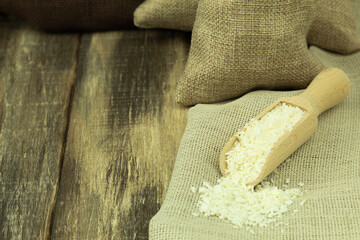 Coconut flakes in a wooden spoon on a wooden background