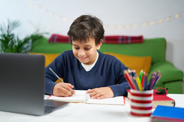 School boy having online classes while sitting at home in quarantine,