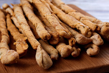 Delicious breadsticks grissini on the wooden table. Italian appetizers.