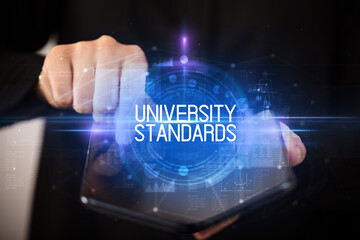 Young man holding a foldable smartphone with UNIVERSITY STANDARDS inscription, educational concept