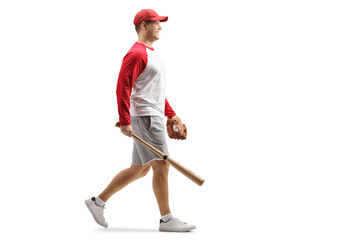 Full length profile shot of a man with a baseball bat and glove walking