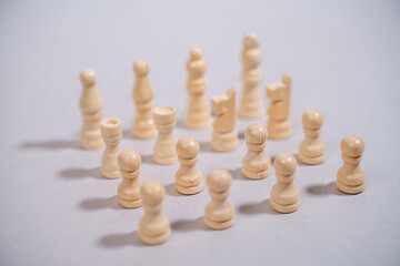 white chess pieces standing against gray background in the shape of a square