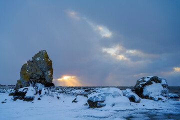 Limestone stack with ocean background during a snowstorm 