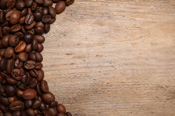 Roasted coffee beans on wooden table, flat lay. Space for text