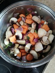 Vegetables like carrot, mushrooms portobello, red onion, broccoli, and celery root and leaves are washed set on the pot with olive oil  for cooking
