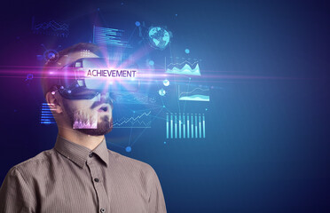 Businessman looking through Virtual Reality glasses with ACHIEVEMENT inscription, new business concept
