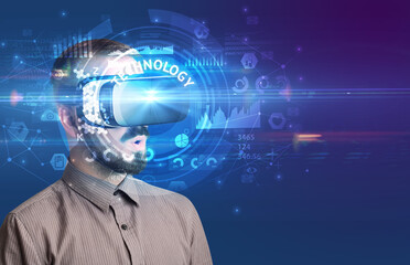 Businessman looking through Virtual Reality glasses with TECHNOLOGY inscription, innovative technology concept