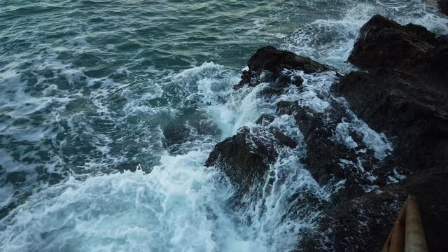 Onda del mare che si frange sula scogliera creando spuma e schizzi d'acqua