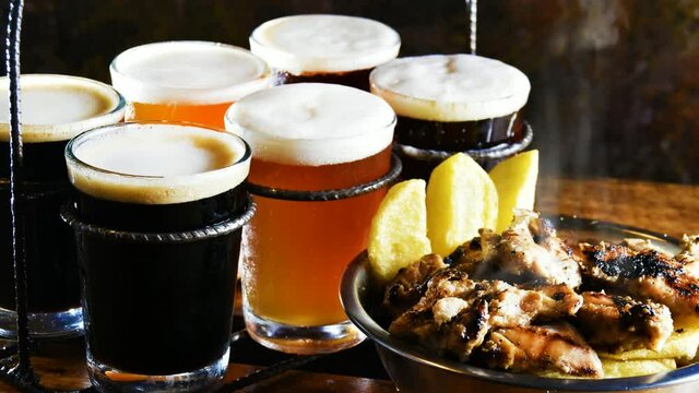 Cerveza artesanal espumosa y picada de pollo asado con papas fritas humeantes