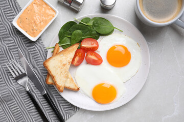 Tasty breakfast with fried eggs, toasts and coffee served on light grey table, flat lay