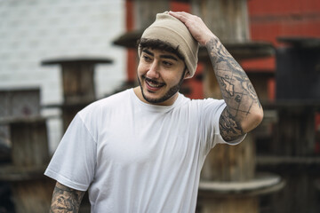 Shallow focus shot of a posing handsome smiling European guy in a hat
