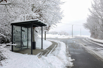 Bus stop by the snowy road in the countryside in winter