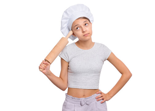 Girl in a chef's hat with emotions holding a rolling pin isolated on a white background.