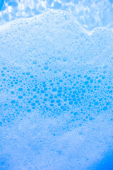 water foam and bubbles of blue color as background. cosmetology concept