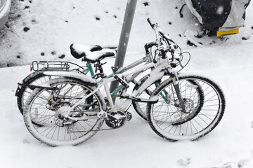 Two locked bicycles covered in snow, winter season