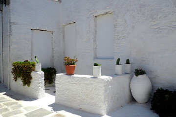 One of the charms of the Greek Cycladic Islands, in the heart of the Aegean Sea are the narrow streets: white houses, small flowered balconies and cobbled stairs