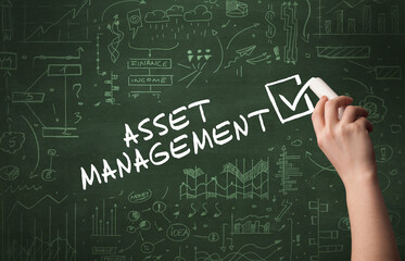 Hand drawing ASSET MANAGEMENT inscription with white chalk on blackboard, new business concept