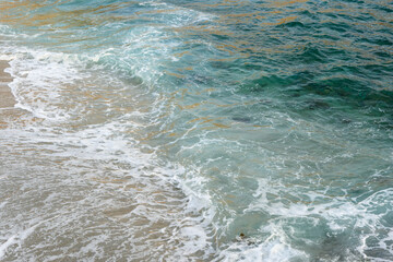 Foaming waves of turquoise sea water on an exotic beach.