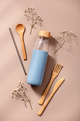 Zero waste, eco friendly concept. Reusable glass bottle and bamboo cutlery.