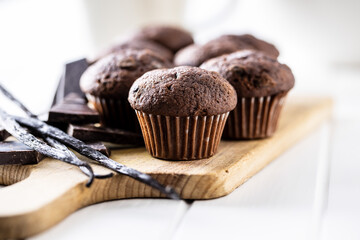 Chocolate muffins. Sweet dark cupcakes with chocolate and vanilla pods.