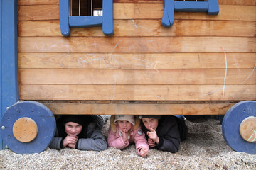 Drei Kinder auf Spielplatz im Versteck