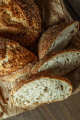 Bread, traditional sourdough bread cut into slices on a rustic wooden background. Concept of traditional leavened bread baking methods. Healthy food.