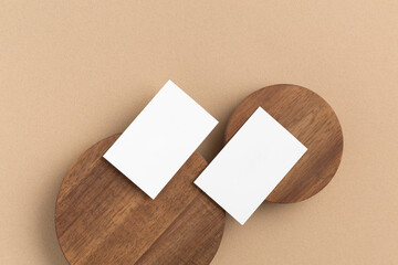 White paper business card mock up on wooden pads on beige background. Top view.