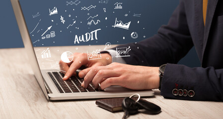 Businessman working on laptop with AUDIT inscription, modern business concept