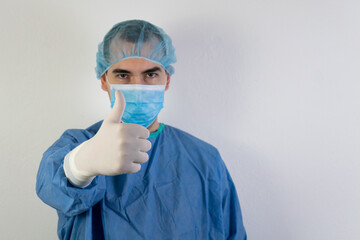 The main subject is out of focus, young male surgeon health care thumbs up