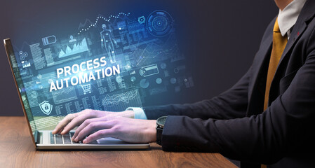 Businessman working on laptop with PROCESS AUTOMATION inscription, cyber technology concept