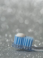 stock photo of a toothbrush with the recommended size of toothpaste equivalent to the size of a pea on a bright gray background. macro photography with copyspace