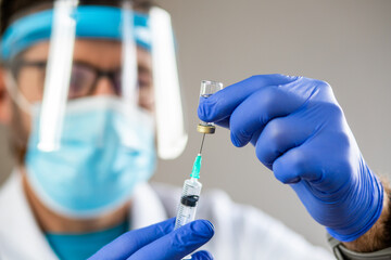 male doctor preparing to give coronavirus vaccine