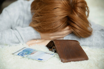 Complete failure, financial problems, lack of money, bankruptcy. Frustrated young girl lying on bed with last cash