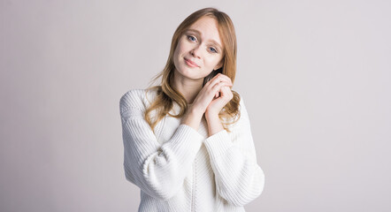 Portrait of a stylish girl on a white background in the studio who is touched and happy