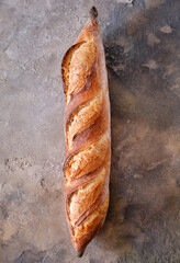 Freshly baked baguette on a stone background.